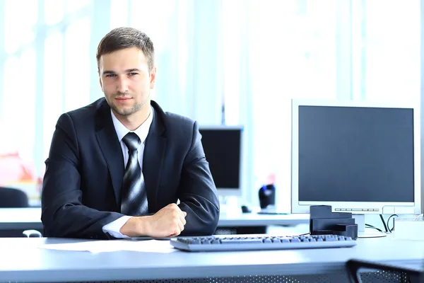 Молодой предприниматель, работающие в офисе, сидя за столом — стоковое фото
