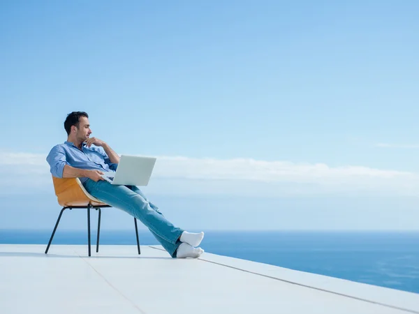 Расслабленной молодой человек у себя дома на балконе — стоковое фото