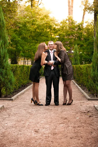 Две девочки поцелуй красивый бизнесмен — стоковое фото