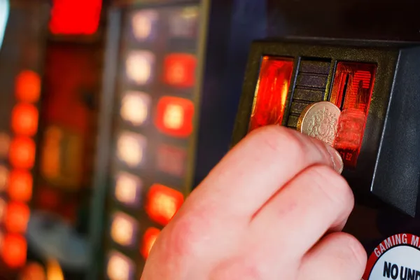 Вставка монет фунт стерлингов в игровой автомат — стоковое фото
