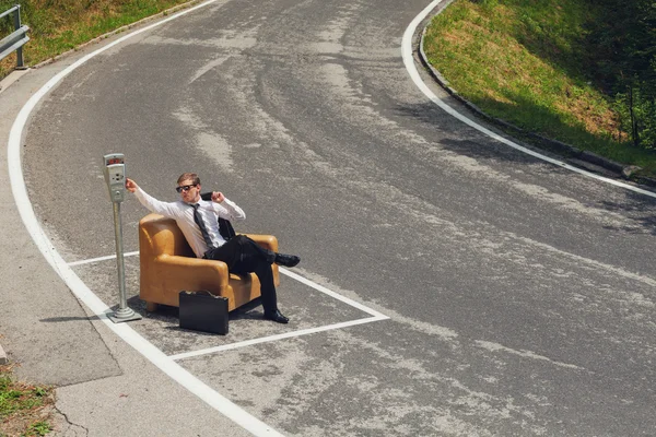 Бизнесмен, сидя на кресле в середине дороги — стоковое фото