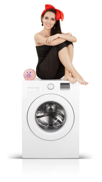 Девочка с копилкой на стиральной машине — стоковое фото
