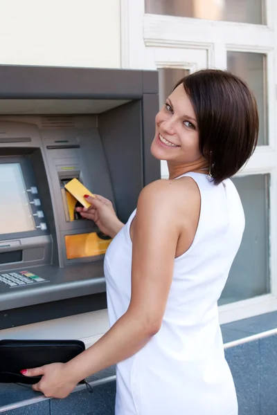 Женщина, забирающая деньги из кредитной карты в атм — стоковое фото